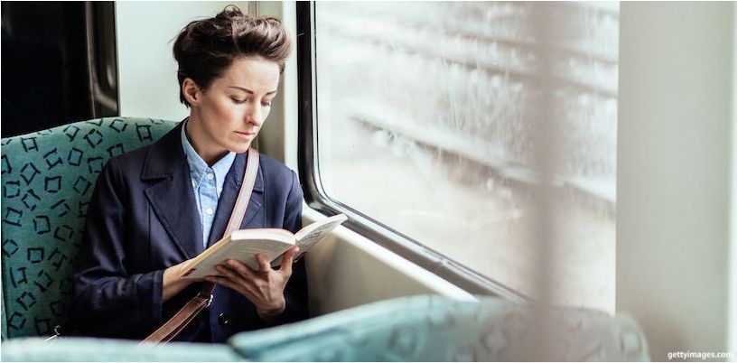 femeia citește în transportul public
