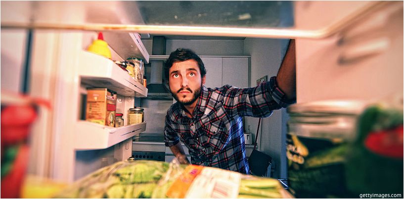 omul se uită în frigider