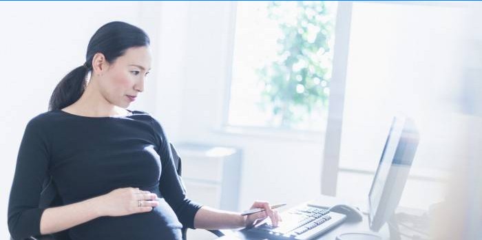 Femeie însărcinată la computer