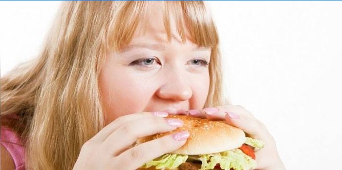Fata mănâncă un hamburger