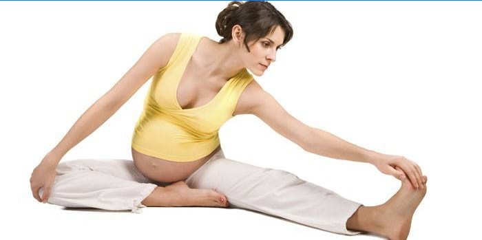 Fata însărcinată care face exerciții de întindere