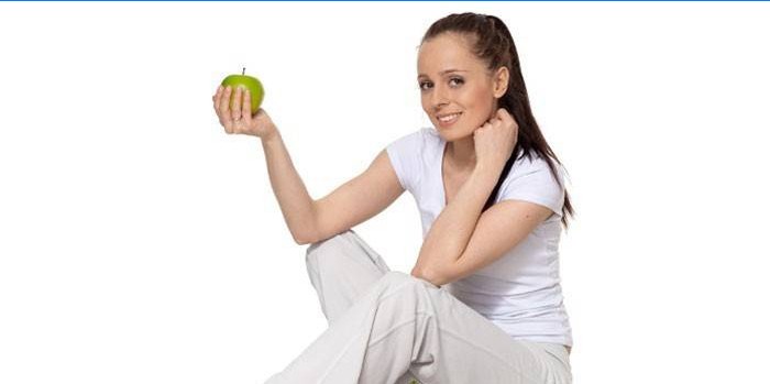 Fata ține mărul în mână