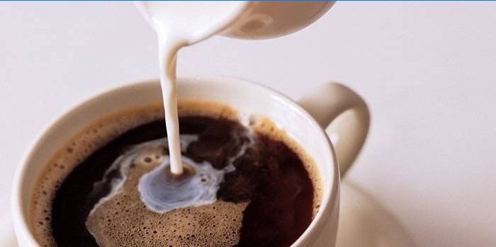 Adăugați lapte într-o ceașcă de cafea