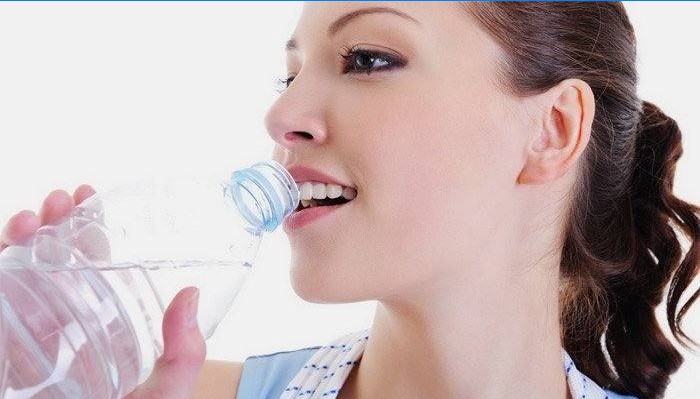 Fata bea apă pentru pierderea în greutate.