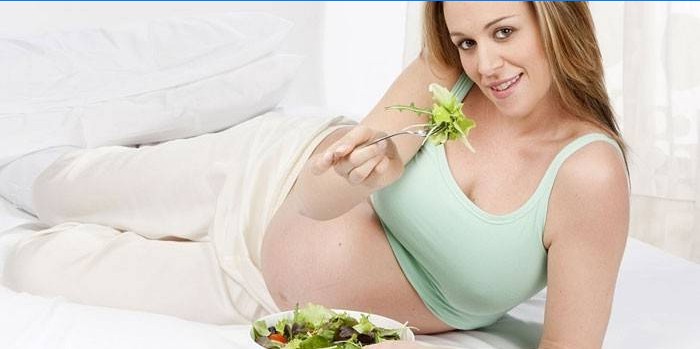Fata însărcinată mănâncă salată
