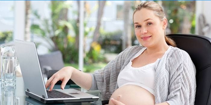 Fata însărcinată la un laptop
