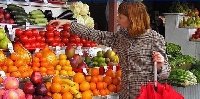 Fata alege legume la piață