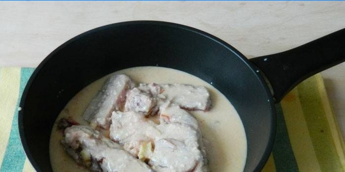 Coaste de porc într-un sos cremos într-o tigaie