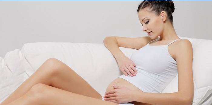Femeie însărcinată care mângâie burtica