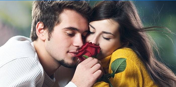 Tip și fată adulmecând un trandafir