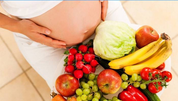 Femeie însărcinată cu legume și fructe