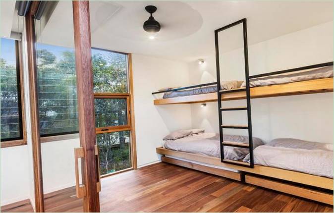 Interioare moderne într-o casă din lemn: paturi supraetajate în dormitorul unei case de pe plajă