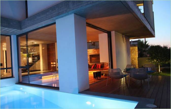Un design interior de casă simplă: o terasă din lemn lângă piscină